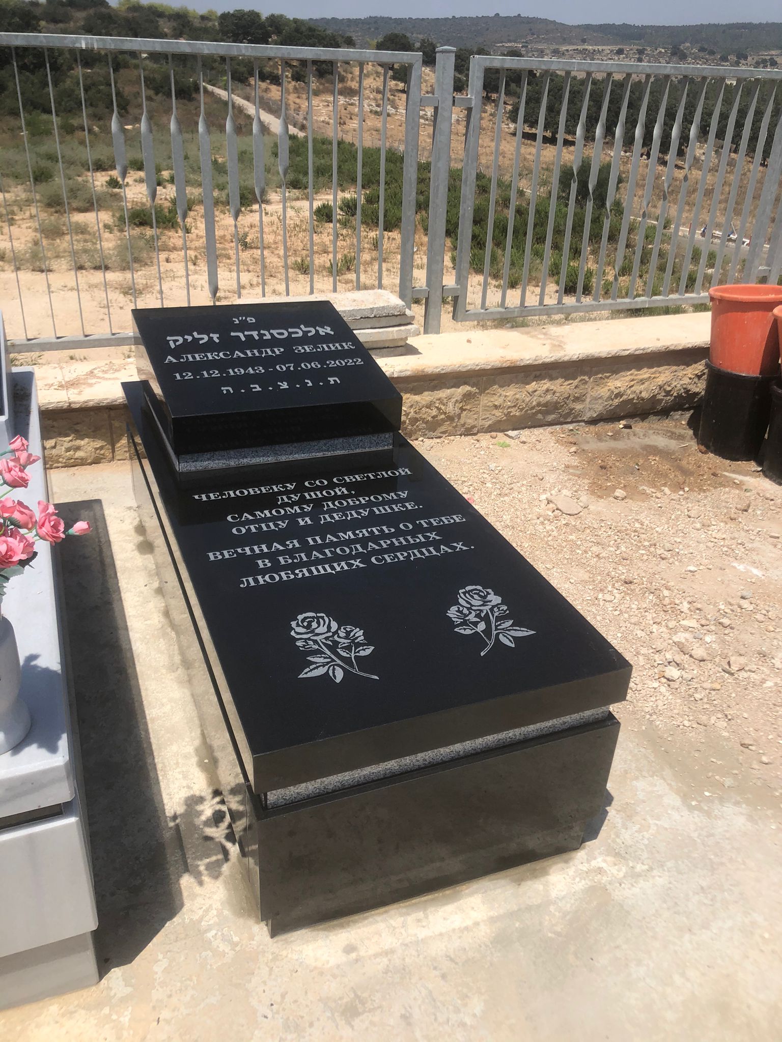 מצבה כפולה מגרניט שחור עם כיתוב ועיטורים