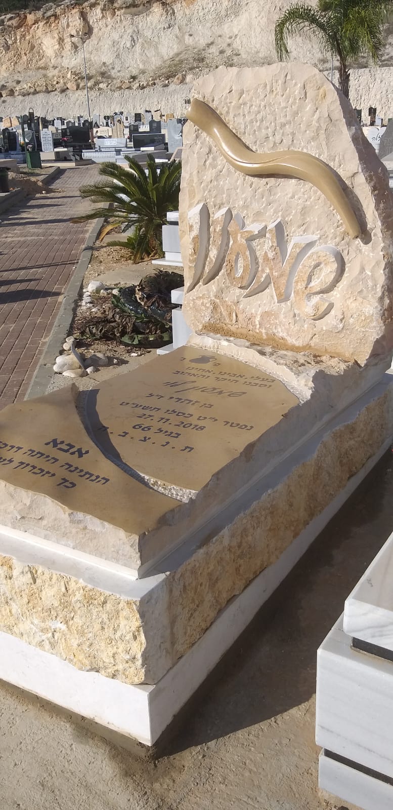 מצבה מאבן טבעית עם גילוף השם שלום ושופר