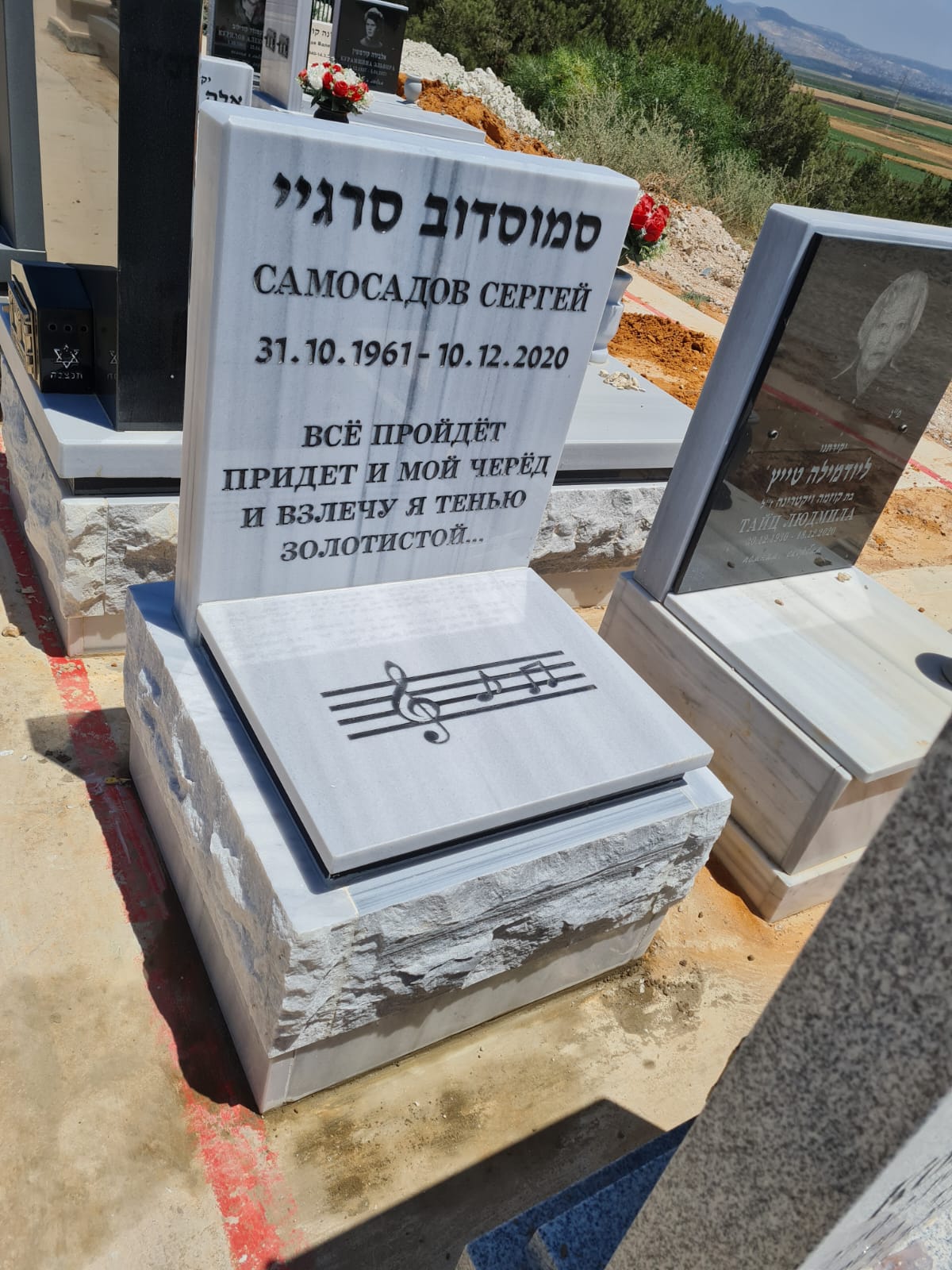 מצבת שיש לבן עם חריטת תווים, שירות בצפון