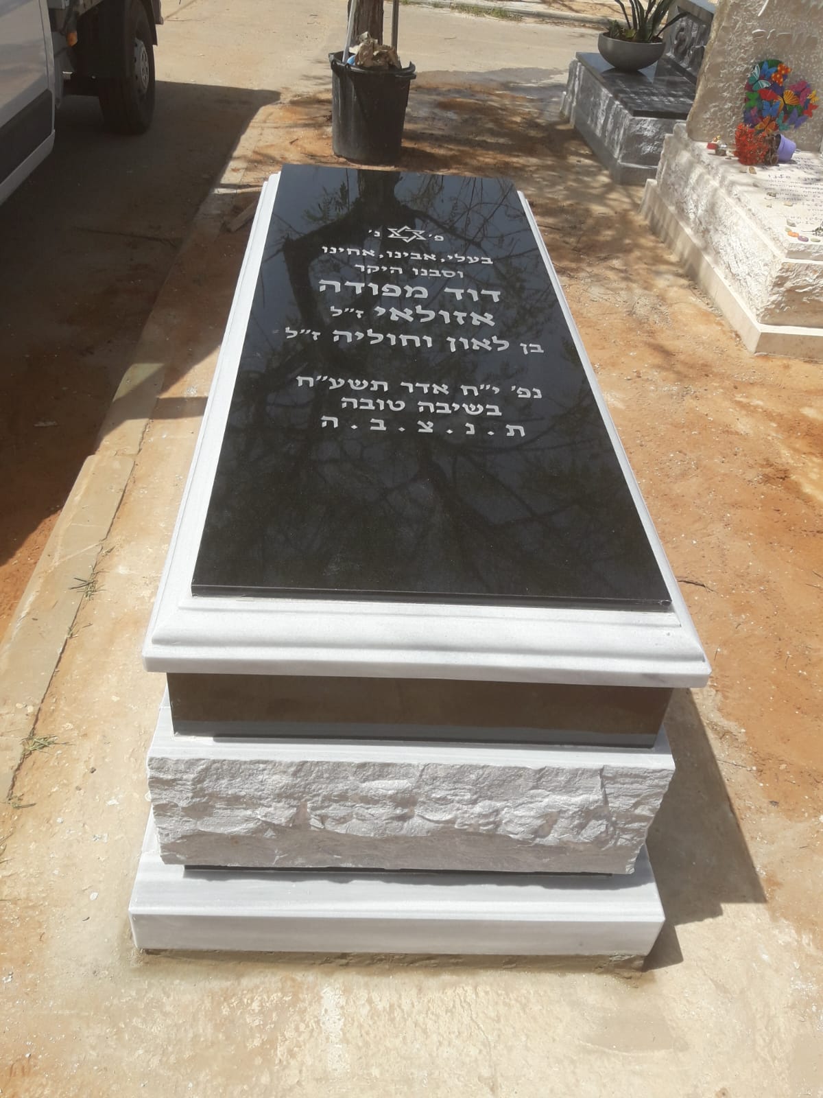 מצבת גרניט שחור עם בסיס אבן מסותת בצפון.
