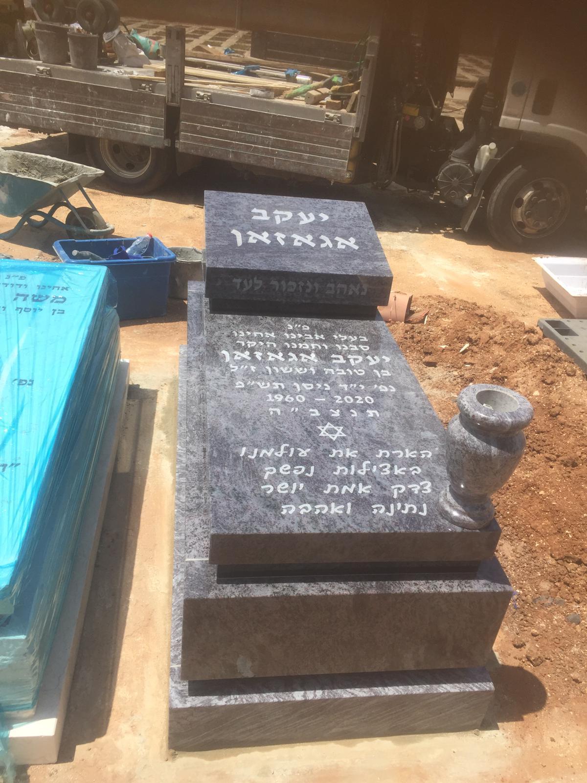 מצבת גרניט אפורה מדורגת עם אגרטל בזמן התקנה