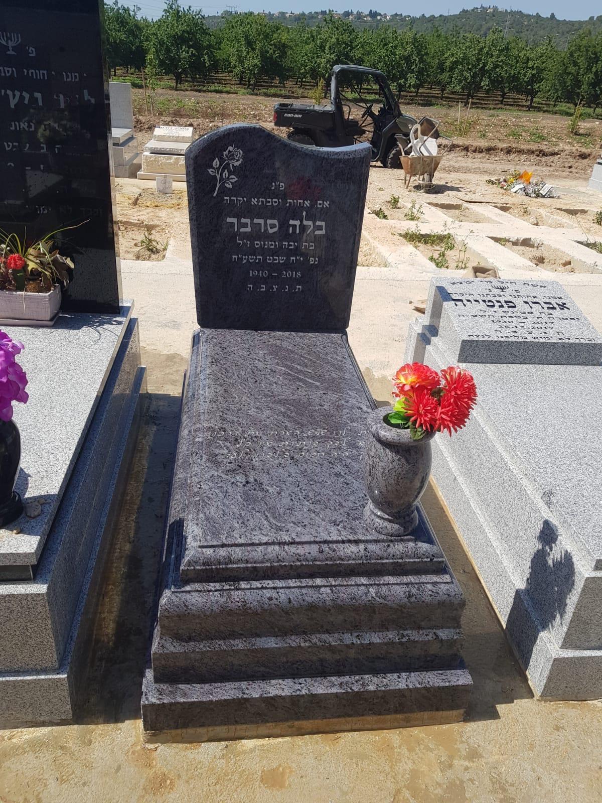 מצבה מאבן כהה עם בסיס מדורג בבית עלמין