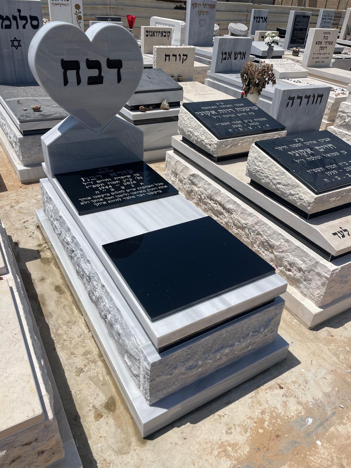 מצבת שיש לבנה עם כיתוב ועיטור לב גדול