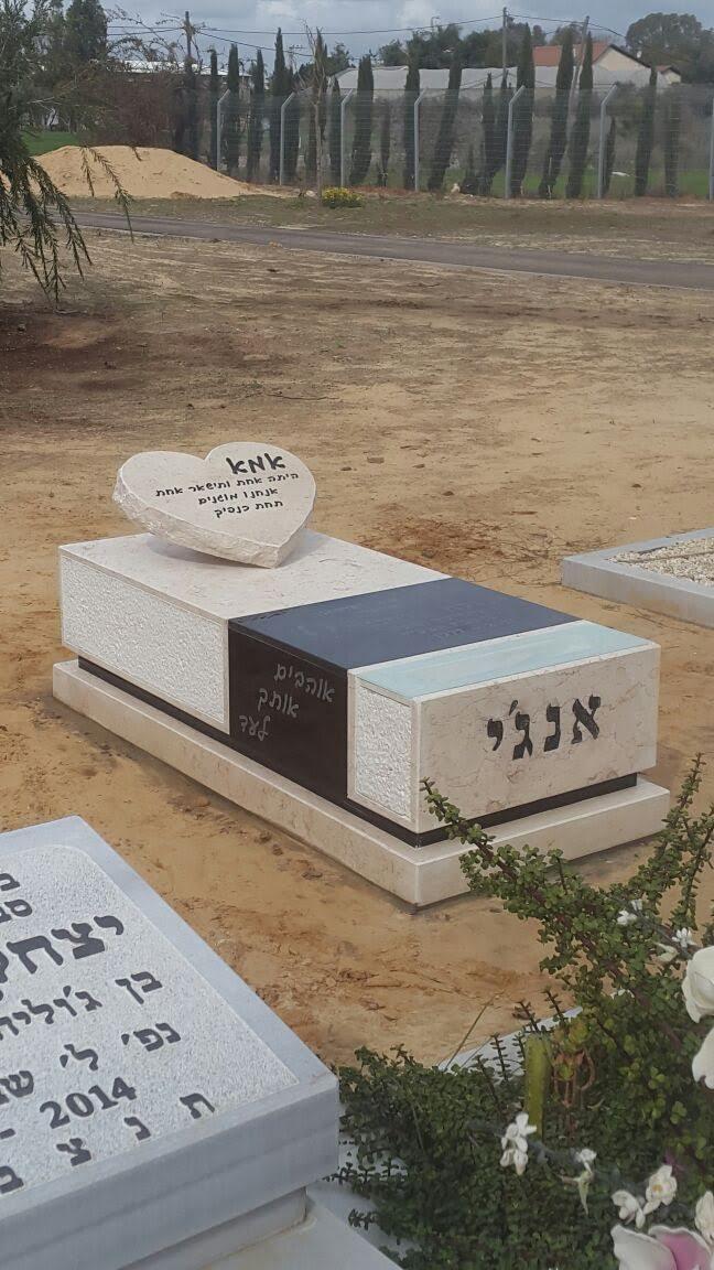 מצבה מעוצבת המשלבת אבן בהירה וכהה עם לב