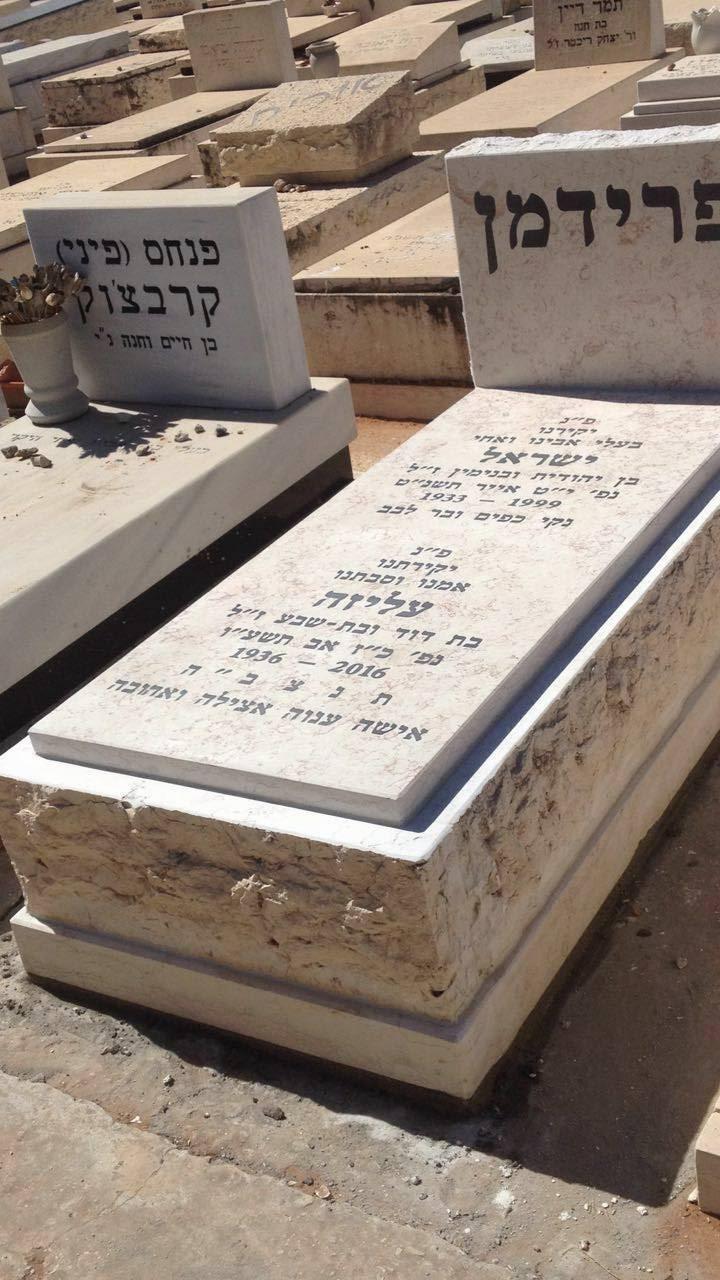מצבה כפולה מאבן עם מסגרת מסותתת בבית עלמין