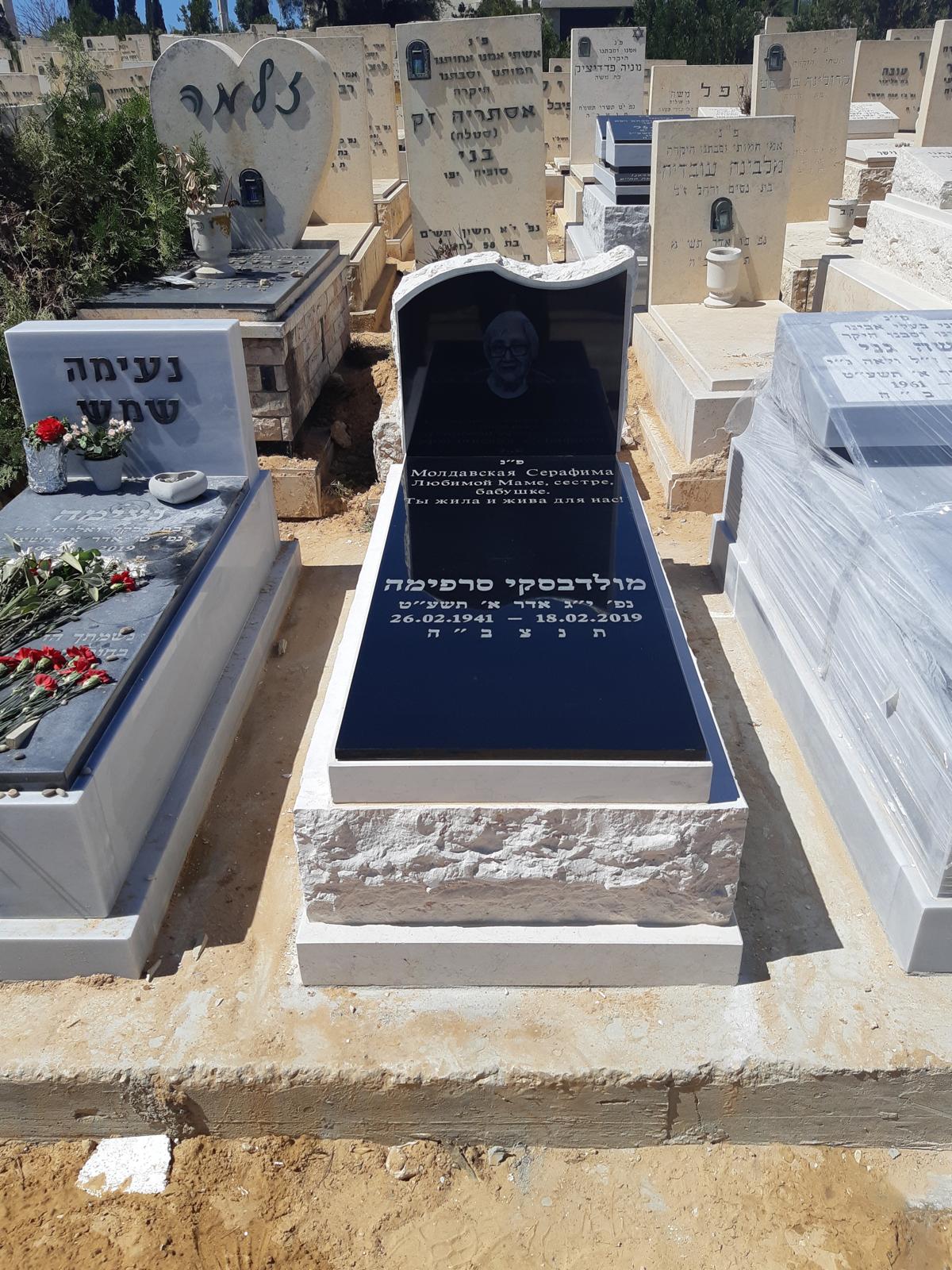 מצבת בזלת שחורה עם בסיס אבן לבנה מסותתת