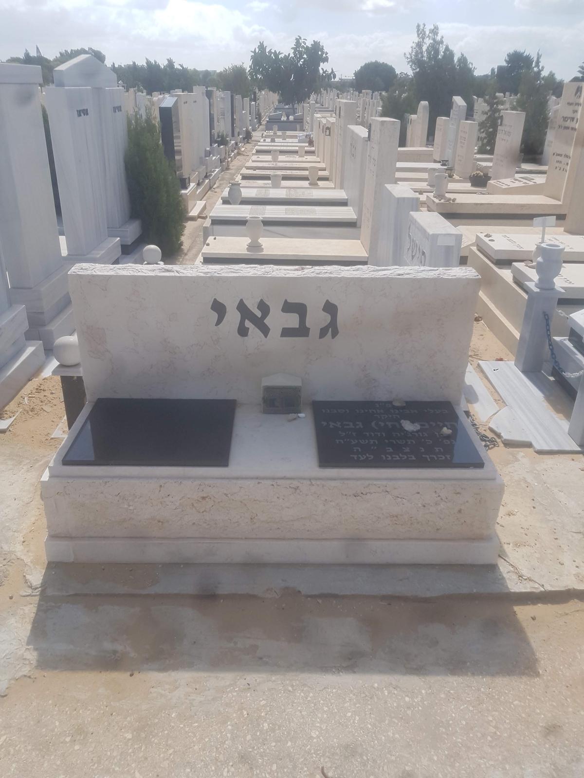 מצבה כפולה מאבן בהירה מסותתת בבית עלמין