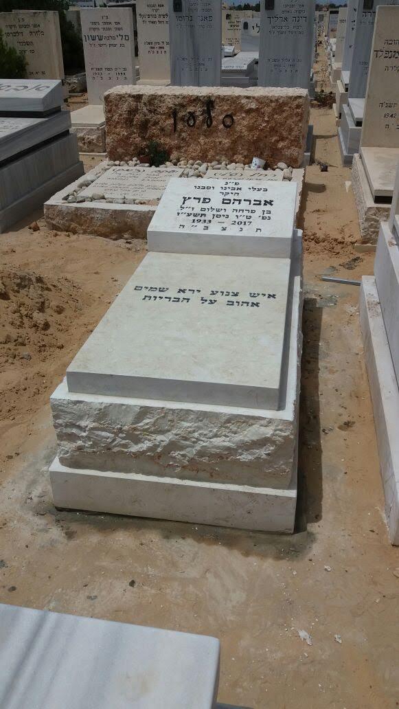 מצבה מדורגת מאבן בהירה עם בסיס וראש מסלע טבעי